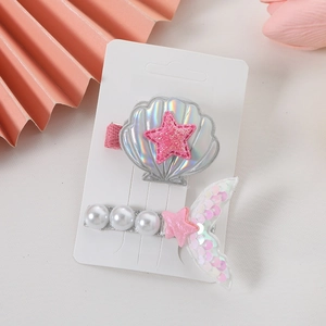 Detail of mermaid tail and shell hair clips with pearls and pink glitter for girls
