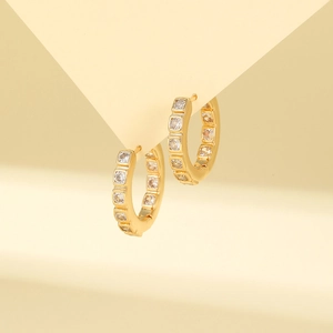 Macro detail of gold hoop earring with pavé-set white cubic zirconia stones