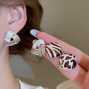 Detail showing animal print enamel earrings including leopard, zebra and cow patterns