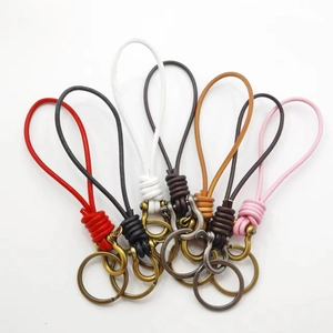Detailed flat lay of braided leather keychains in six assorted colors with metal clasps
