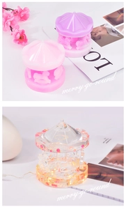 Detail of carousel resin molds in pink, purple and a glowing LED version on desk