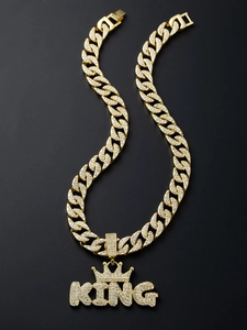 Close-up of gold iced out King Crown pendant with thick Cuban link chain in hip hop style