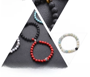 Detail of natural lava stone beads with crown charm and textured volcanic rock surfaces