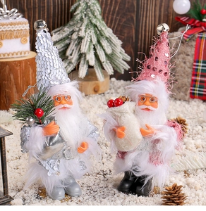 Detail of silver and pink sequin Santa ornaments with bells on festive snowy background