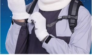 Detail of white winter knit gloves with ribbed cuffs and simple black decorative textures