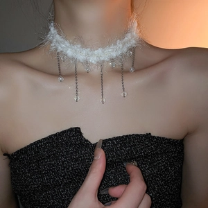 Detail view of white plush choker necklace with silver tassels and crystal beads