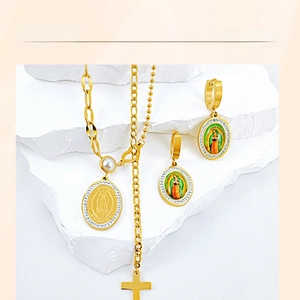 Detailed macro view of golden Virgin Mary medals and cross pendant set on stone base