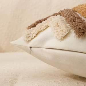 Close-up of bohemian tufted cushion cover showing beige cotton fabric and hidden zipper