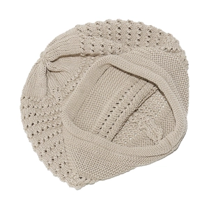 Detailed macro view of beige crochet knit beanie with hollow-out patterns and ribbed edge