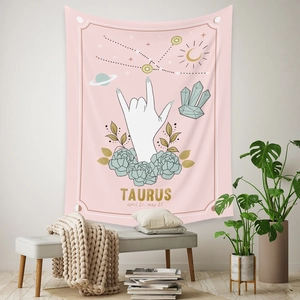 Detail of pink Taurus zodiac tapestry with floral patterns and celestial motifs