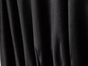 Detailed macro view of the silky black sequin fabric with smooth drapes and fine texture