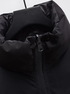 Detailed close-up of the black puffer vest collar and high-quality zipper closure