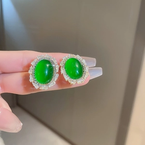 Macro shot of vintage emerald green stone earrings with shiny cubic zirconia border