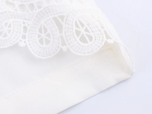 Gros plan sur les détails en dentelle blanche et les coutures de ce pantalon droit