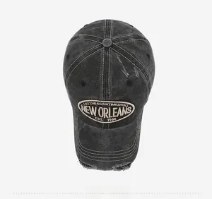 Top view of distressed charcoal grey baseball cap featuring vintage embroidery and ripped details