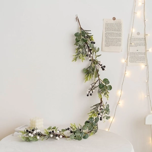 Frosted Christmas eucalyptus garland with white berries hanging in a cozy Nordic decor