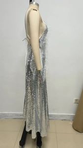 Side view of silver sequin evening gown with halter neck fringe and mesh details on mannequin