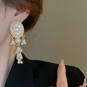 Vintage gold oval pearl tassel earrings with French style design on model