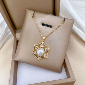 Macro shot of gold star-shaped necklace with white pearl and sparkling zircons
