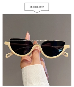 Detail of cream semi-rimless cat eye sunglasses with gold bridge and dark lenses