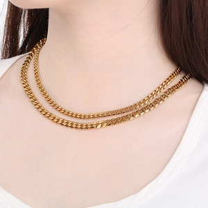 Close-up of double-layered 18K gold-plated Cuban chain necklace worn by a model