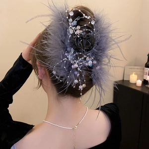 Detail of elegant gray feather hair claw clip with crystal glass beads for formal styling