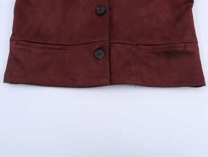 Detail view of burgundy faux suede jacket hem featuring textured fabric and black buttons