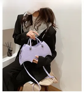 Detail showing lavender bat-shaped PU leather bag with embroidered spiderweb stitching