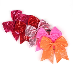 Gros plan de cinq nœuds papillons à paillettes colorés dans les tons rose et rouge