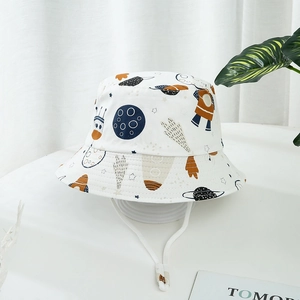 Détail d'un chapeau de soleil blanc pour enfant avec motifs d'espace et cordon réglable