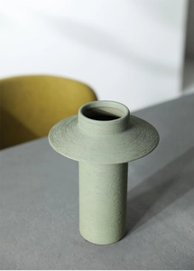 Detail of sage green ceramic vase showing fine horizontal textures and matte finish