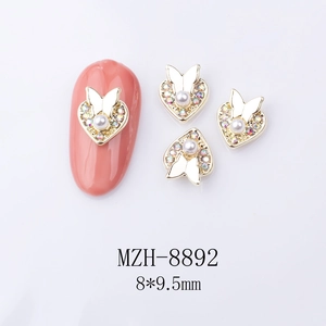 Detail of 8x9.5mm gold nail art charms with heart shape, pearls and butterfly crystals