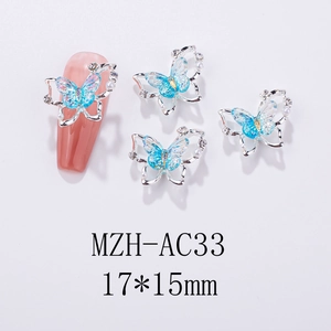 Detailed macro view of laser aurora butterfly nail charms with pearls and silver frame