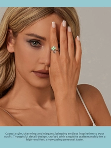 Close-up of a silver four-leaf clover open ring with green enamel on a finger