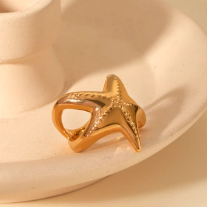 Macro shot of 18K gold plated starfish ring on minimalist ceramic holder