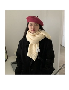 Close-up of thick knitted white scarf and pink wool beret on a model in black coat