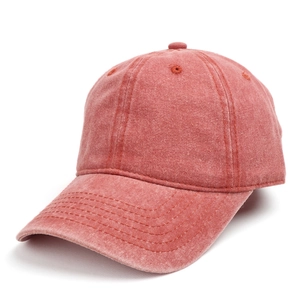 Detailed side view of washed red cotton baseball cap with ventilation holes and stitching