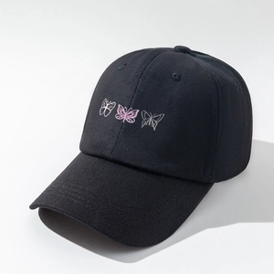 Detailed close-up of three butterfly embroidery patterns on a black cotton baseball cap