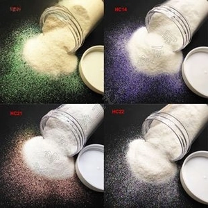 Macro view of pearlescent fine glitter powder in jars for nail art and DIY crafts