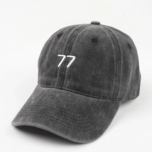 Close-up of white 77 embroidery on vintage washed dark grey cotton baseball cap fabric