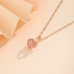 Elegant rose gold crown necklace featuring a sparkling zircon pendant on pink background