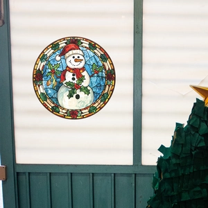 Macro shot of a cartoon snowman Christmas window sticker with stained glass texture on glass