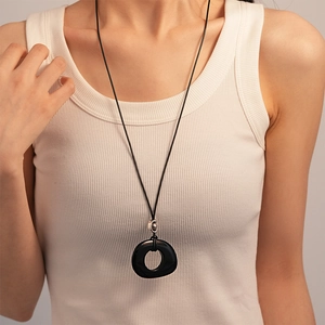 Retro resin oval geometric pendant necklace with black cord shown on a model