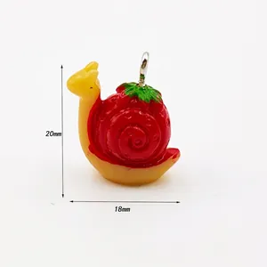 Detail view of a cute 20mm strawberry snail charm with red shell and yellow body