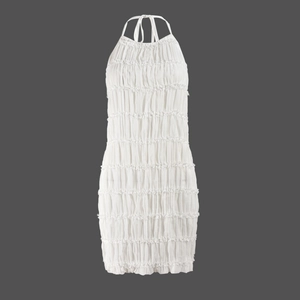 Detail of white pleated halter dress featuring layered ruffles and textured fabric