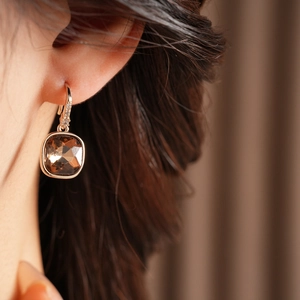 Gros plan de boucles d'oreilles en zircon ambre sur un modèle avec placage or rose