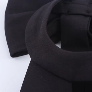 Détail de la robe licou noire avec nœud papillon montrant les coutures et la texture du tissu