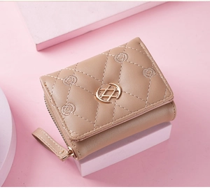Detailed close-up of a beige quilted PU leather wallet with a golden metal ring buckle