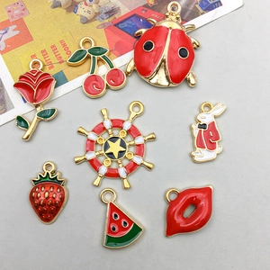 Detail of red enamel apple cherry and rose charms for DIY jewelry making