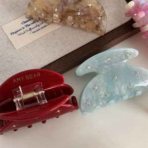 Close-up of sparkling acetate hair claws with rhinestones in four elegant colors